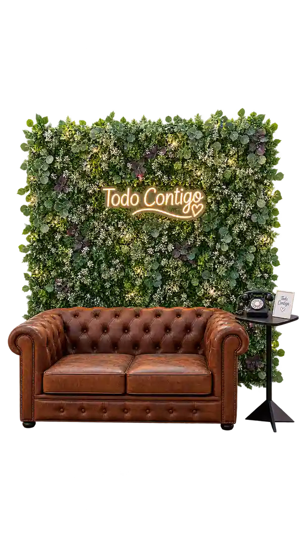 Photocall con muro vegetal, neón &laquo;Todo Contigo&raquo; y sofá chesterfield de cuero